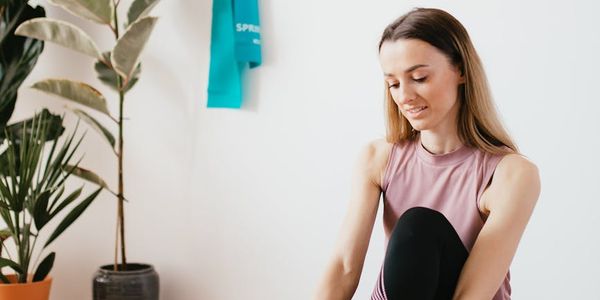 Close-up of a yoga mat and a water bottle on a wooden floor.