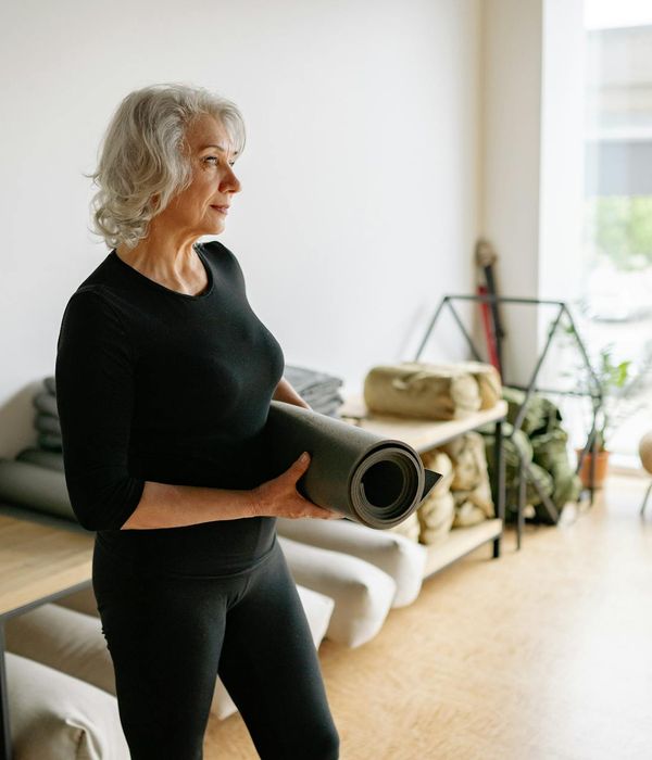 Woman performing a fluid yoga sequence on a mat in a bright room.